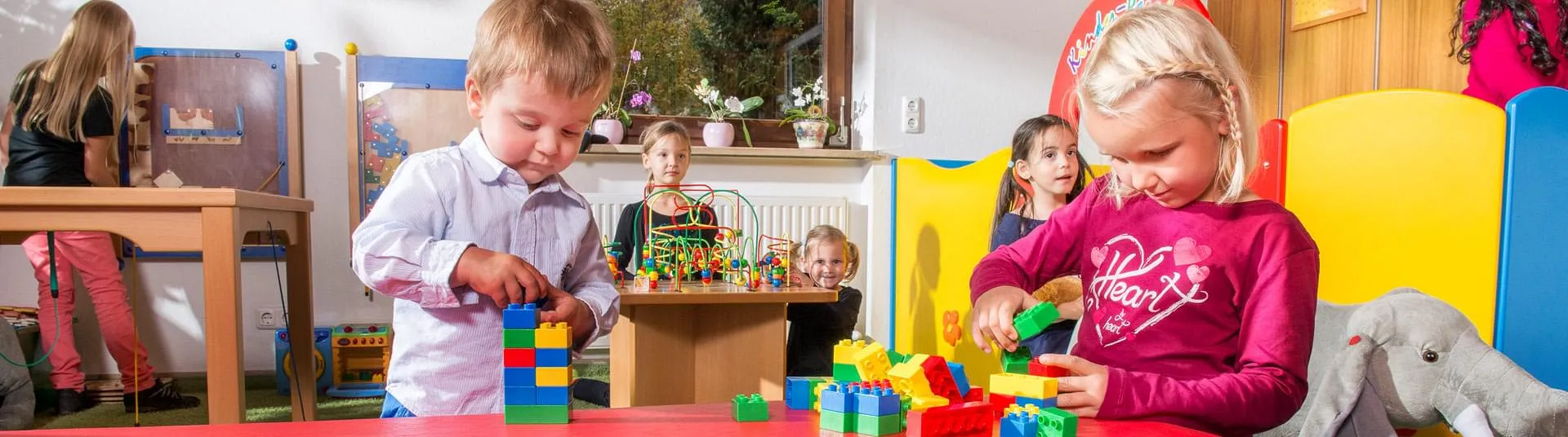 Kinder spielen mit Duplo im Spielbereich